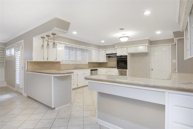 kitchen featuring sink, hanging light fixtures, kitchen peninsula, black oven, and white cabinets