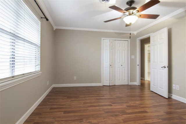 unfurnished bedroom with ceiling fan, dark hardwood / wood-style floors, crown molding, and a closet