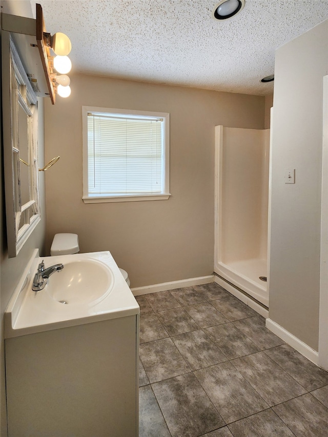 bathroom with vanity, a textured ceiling, and walk in shower