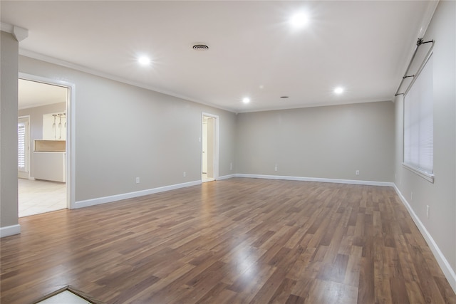 empty room with hardwood / wood-style floors and ornamental molding