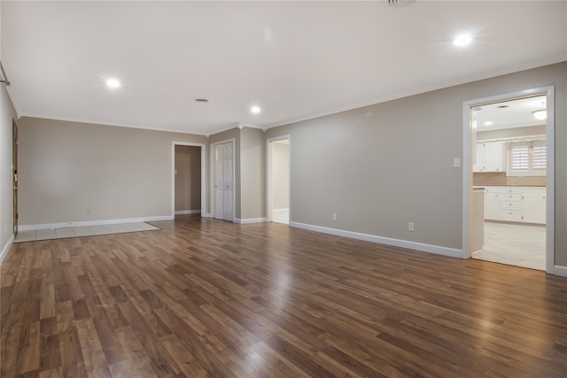 empty room featuring crown molding and dark hardwood / wood-style flooring