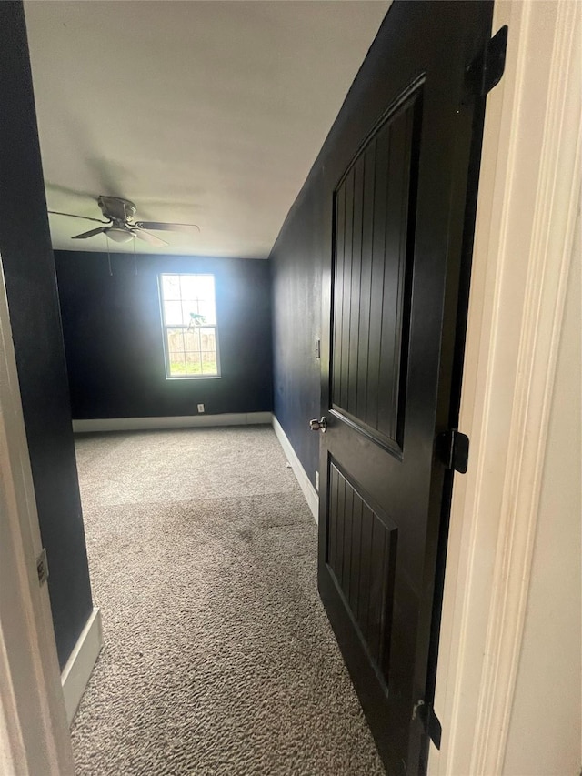 carpeted spare room featuring ceiling fan