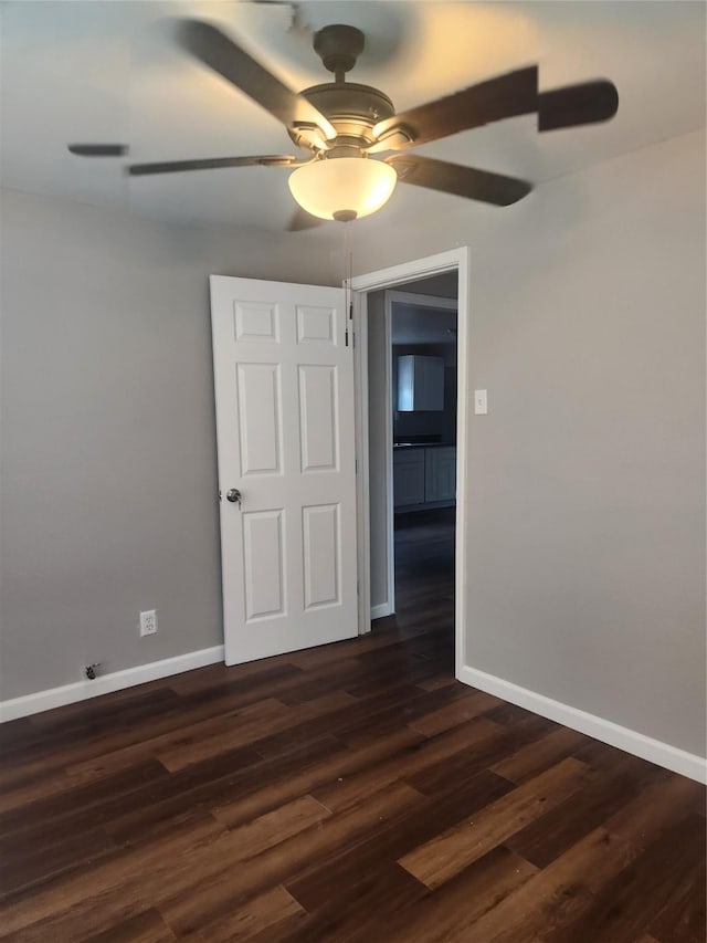 empty room featuring dark hardwood / wood-style floors and ceiling fan