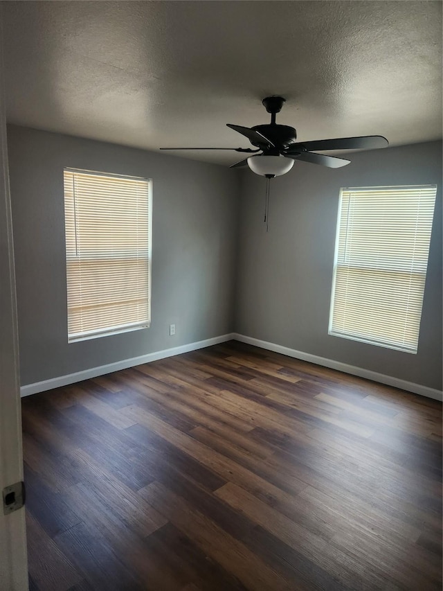 spare room with a textured ceiling, ceiling fan, and dark hardwood / wood-style floors