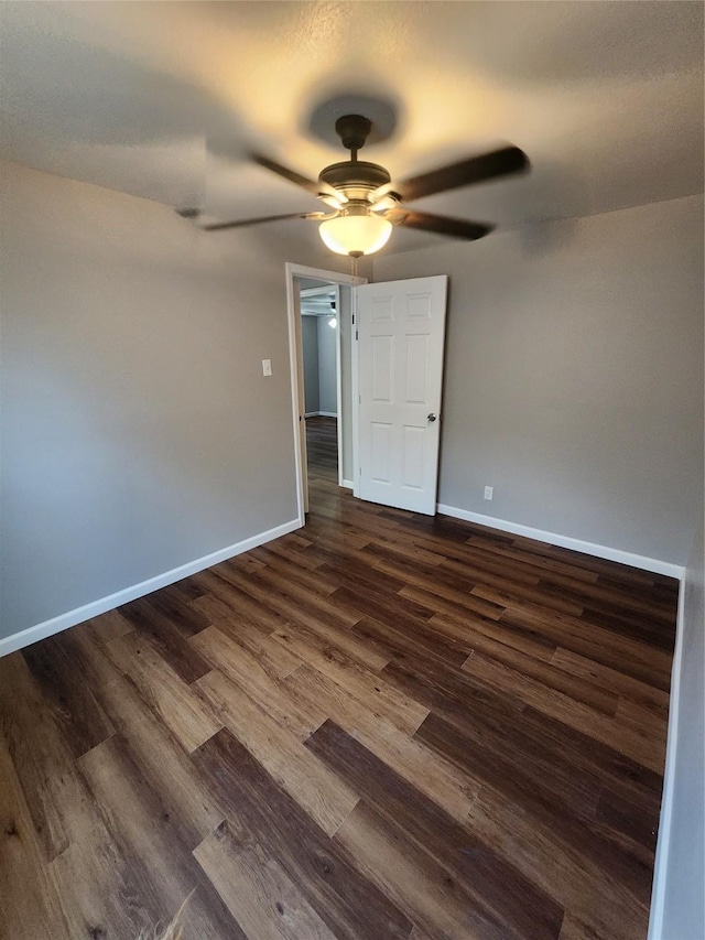 empty room featuring ceiling fan and dark wood-type flooring