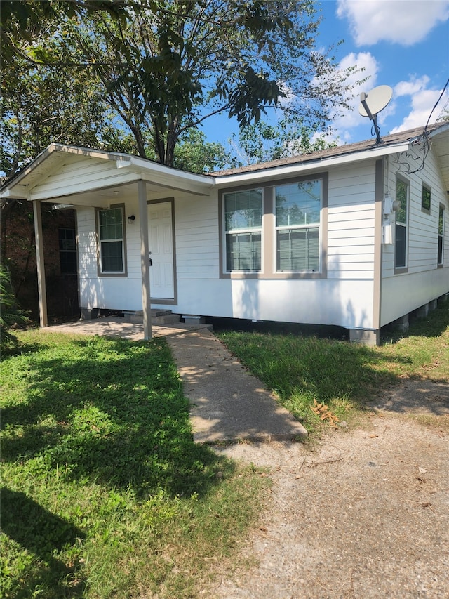 view of front of property featuring covered porch and a front lawn