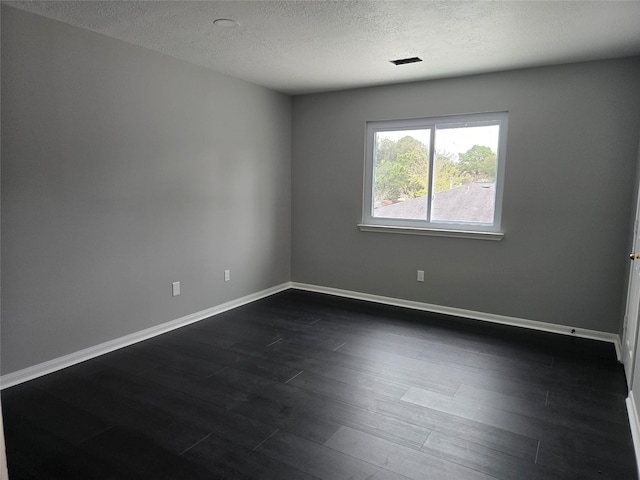 unfurnished room with dark hardwood / wood-style flooring and a textured ceiling