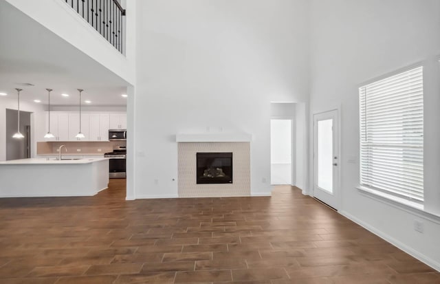 unfurnished living room featuring a high ceiling and sink