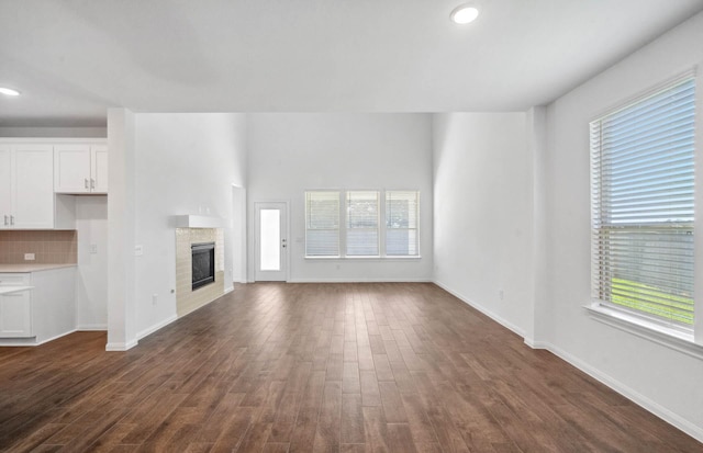 unfurnished living room featuring dark hardwood / wood-style floors and a healthy amount of sunlight