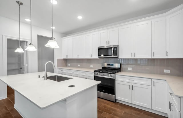 kitchen featuring white cabinets, hanging light fixtures, sink, and appliances with stainless steel finishes