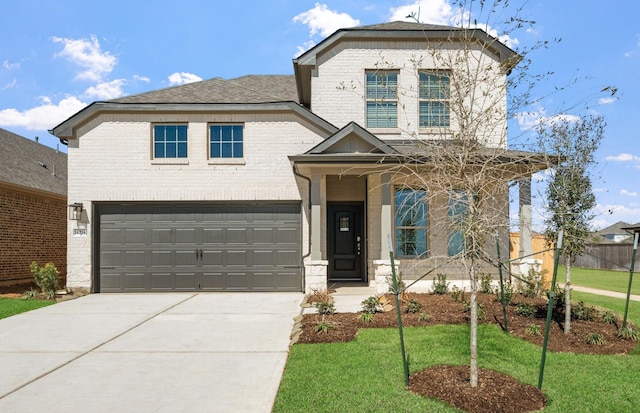 view of front of property with concrete driveway, brick siding, a front lawn, and an attached garage