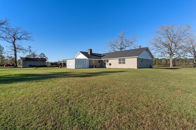 rear view of house featuring a lawn