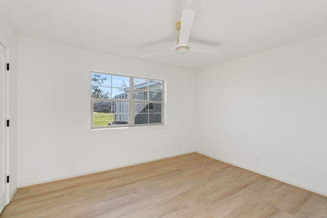 empty room with ceiling fan and light hardwood / wood-style flooring