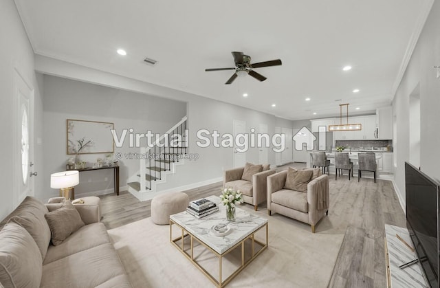 living room with light wood-type flooring, ceiling fan, and ornamental molding