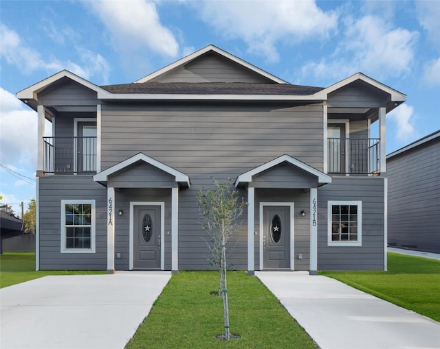 front of property with a balcony and a front yard