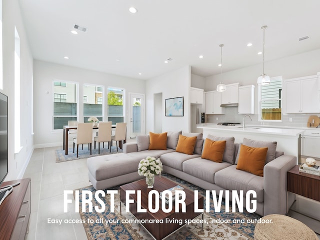 living room featuring sink and light tile patterned floors