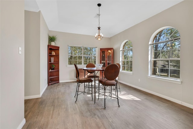 dining area with a chandelier and light hardwood / wood-style flooring