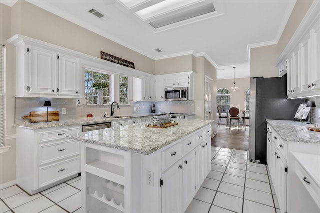 kitchen featuring white cabinets, a kitchen island, stainless steel appliances, and light tile patterned floors