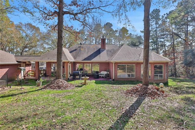 rear view of house with a patio and a lawn