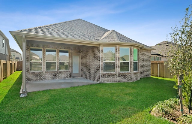 rear view of property with a lawn and a patio