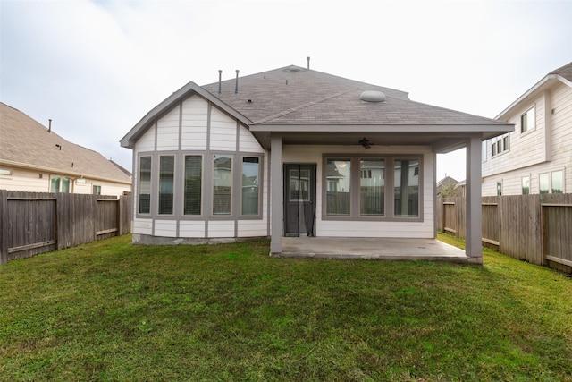 rear view of house with a patio, ceiling fan, and a lawn