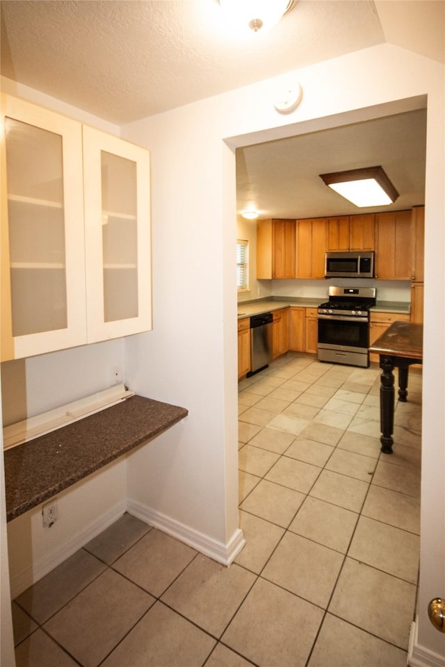 kitchen featuring light tile patterned flooring and appliances with stainless steel finishes