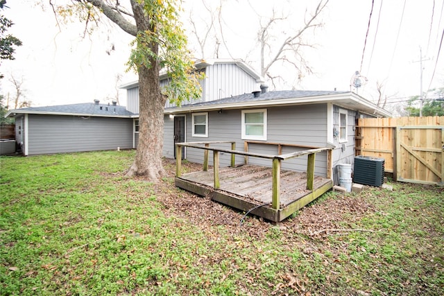 back of property featuring a yard, cooling unit, and a wooden deck