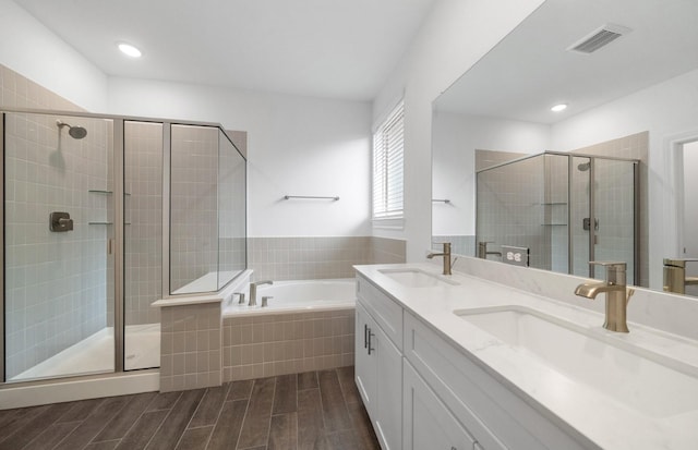 bathroom featuring vanity and independent shower and bath