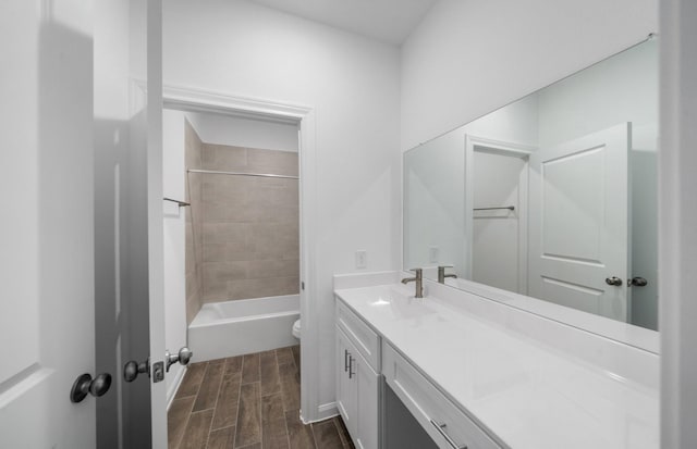 full bathroom with tiled shower / bath, vanity, and toilet