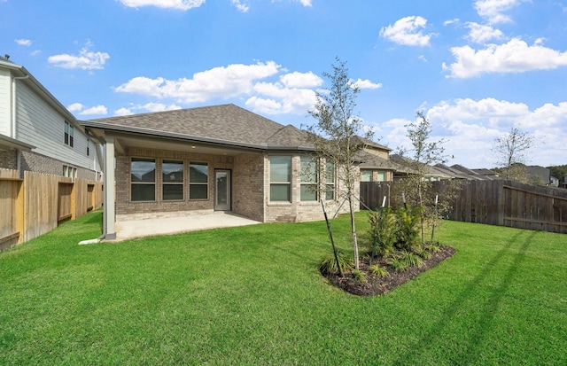 back of property with a lawn and a patio area