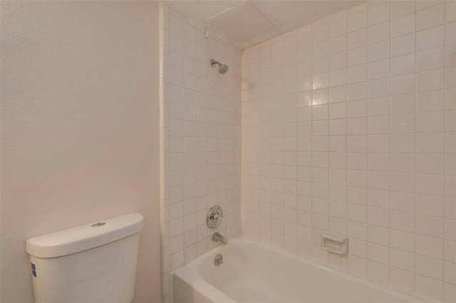 bathroom featuring tiled shower / bath combo and toilet