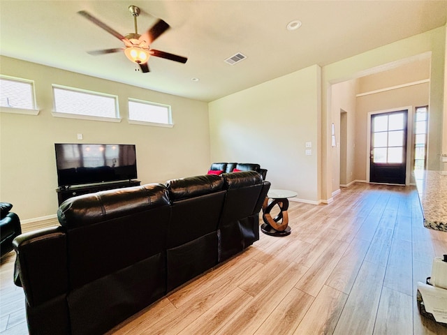 living room with plenty of natural light, ceiling fan, and light hardwood / wood-style flooring