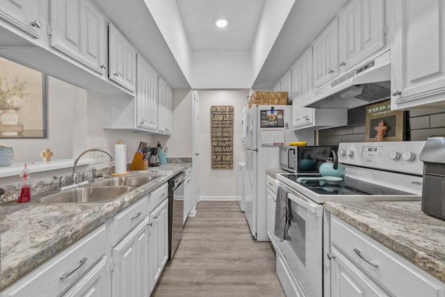 kitchen with white cabinetry, sink, stainless steel appliances, light stone counters, and light hardwood / wood-style flooring