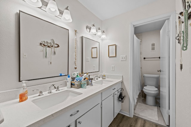 bathroom with hardwood / wood-style floors, vanity, toilet, and a shower with curtain