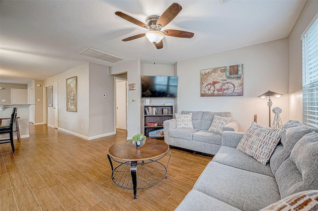 living room featuring light wood-type flooring and ceiling fan