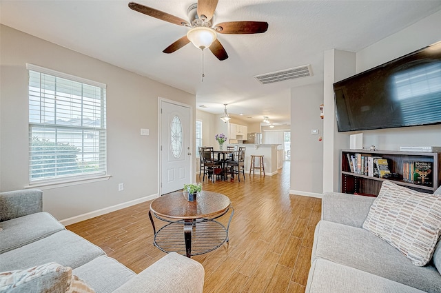 living room featuring light hardwood / wood-style floors and ceiling fan