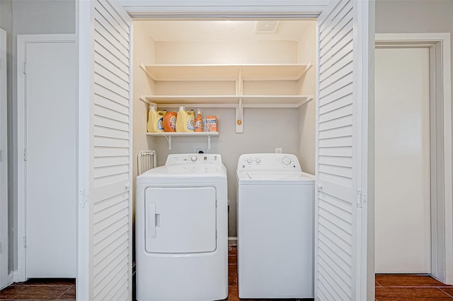 clothes washing area with dark hardwood / wood-style flooring and independent washer and dryer