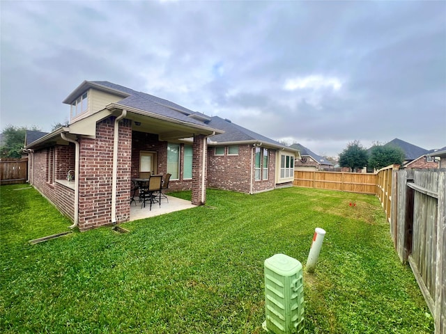 rear view of property featuring a yard and a patio