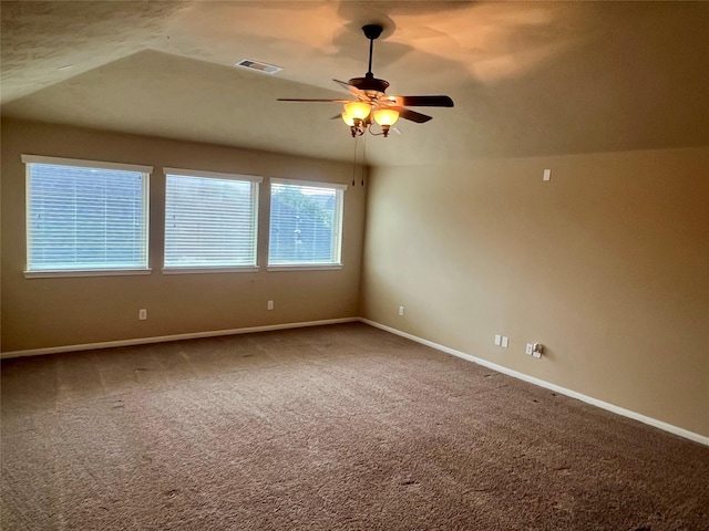 empty room with carpet floors, vaulted ceiling, and ceiling fan