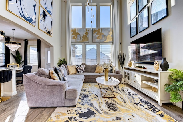 living room featuring a healthy amount of sunlight, hardwood / wood-style floors, and a chandelier