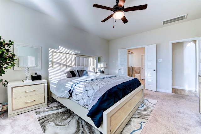 bedroom with ensuite bathroom, ceiling fan, and light colored carpet