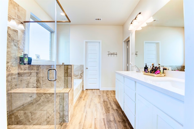 bathroom with vanity, hardwood / wood-style floors, and plus walk in shower