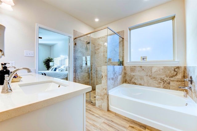 bathroom featuring vanity, hardwood / wood-style flooring, and separate shower and tub