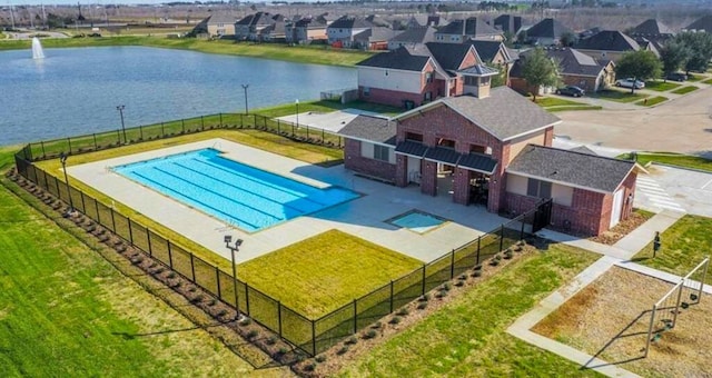 view of pool with a yard and a water view