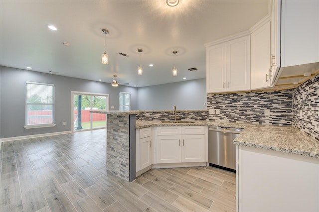 kitchen with stainless steel dishwasher, ceiling fan, sink, decorative light fixtures, and white cabinetry