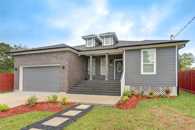 view of front of home featuring covered porch, a garage, and a front lawn