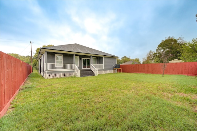 rear view of property featuring a porch and a yard