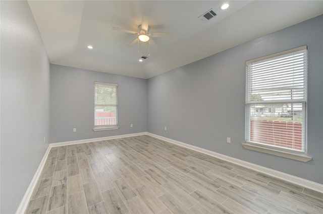 empty room with ceiling fan, light wood-type flooring, and vaulted ceiling