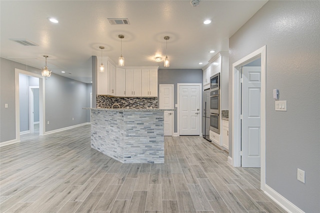 kitchen featuring built in microwave, white cabinets, hanging light fixtures, and light hardwood / wood-style floors