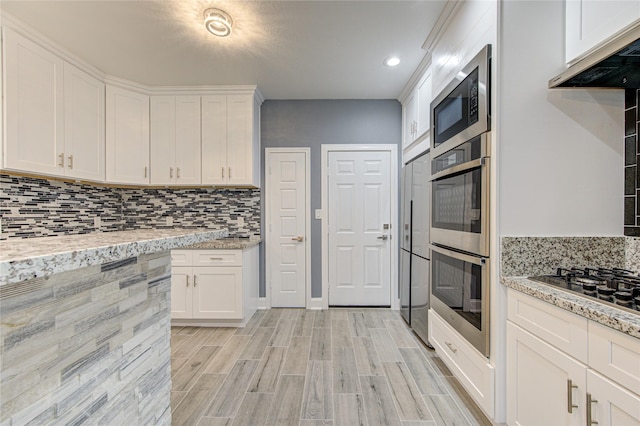 kitchen featuring light stone countertops, white cabinetry, and stainless steel appliances